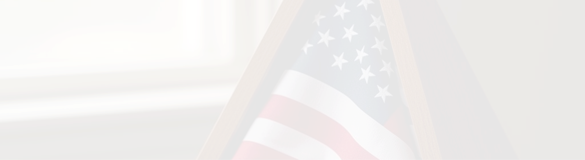 Folded American flag resting on weathered wood in remembrance of fallen service members.